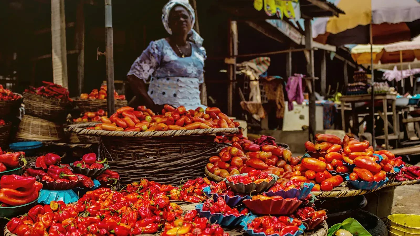 Vendeur africain devant un étal de produits frais — image du commerce de quartier