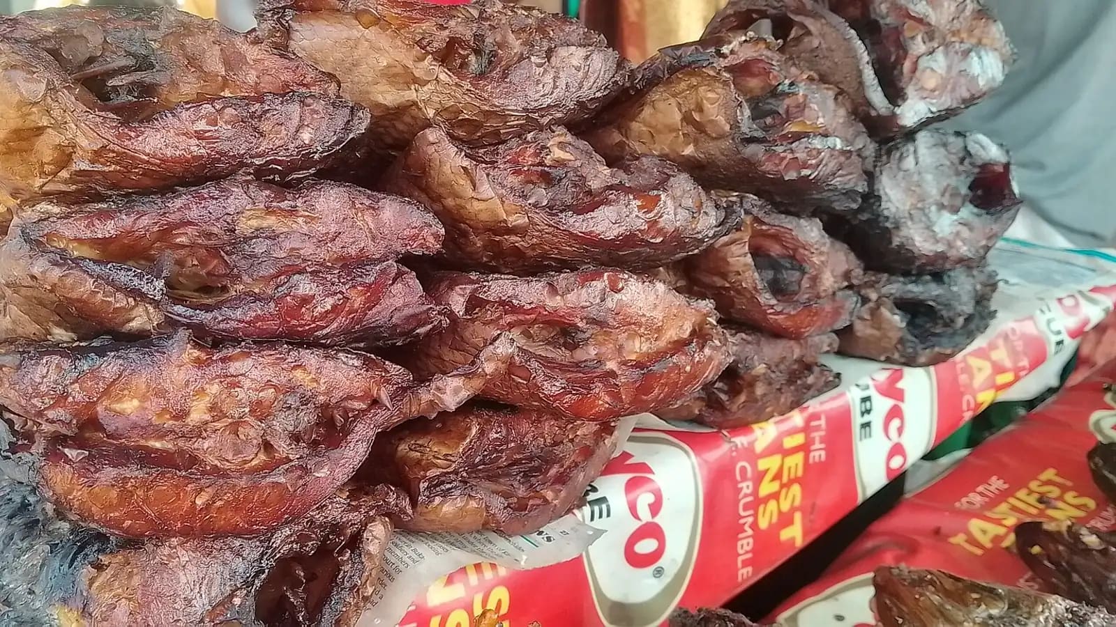 Poissons fumés présentés dans des bassines sur un étal de marché