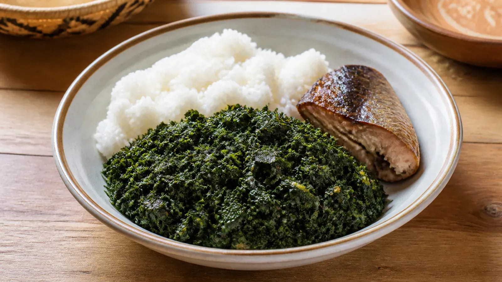 Assiette de pondu vert sombre servie avec du riz blanc et un morceau de poisson fumé